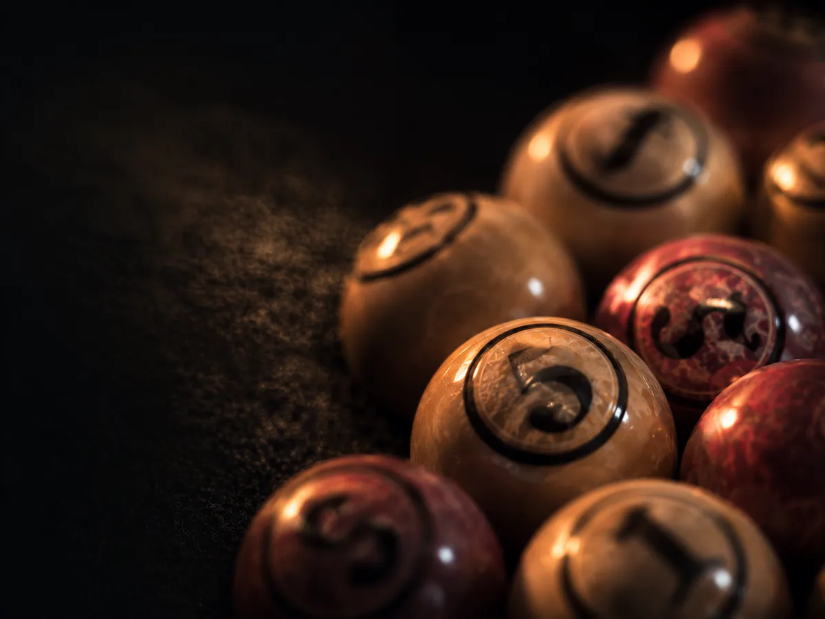 Abstract close-up of numbered bingo balls on dark felt
